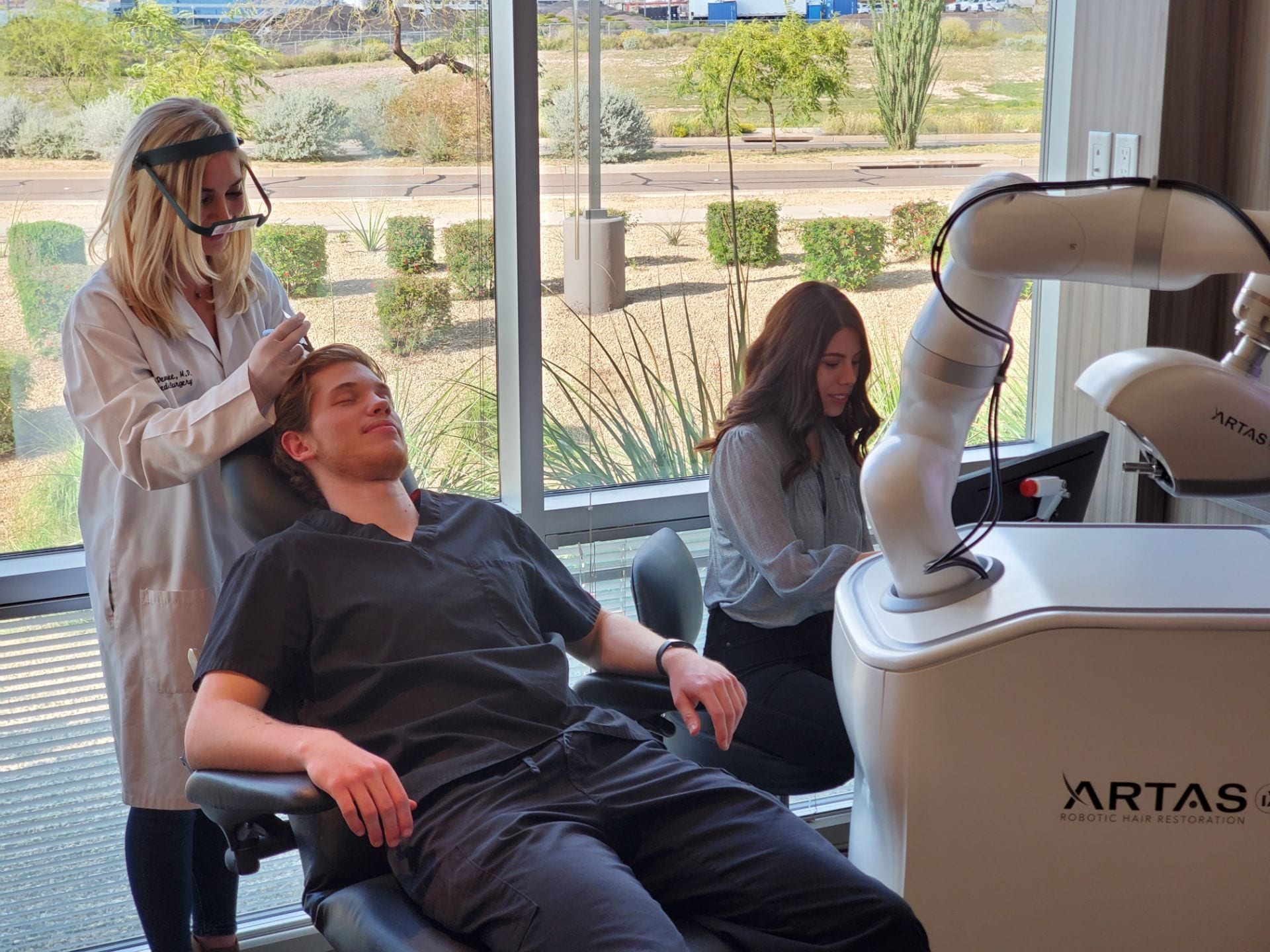 Robotic hair restoration procedure being done on a man.