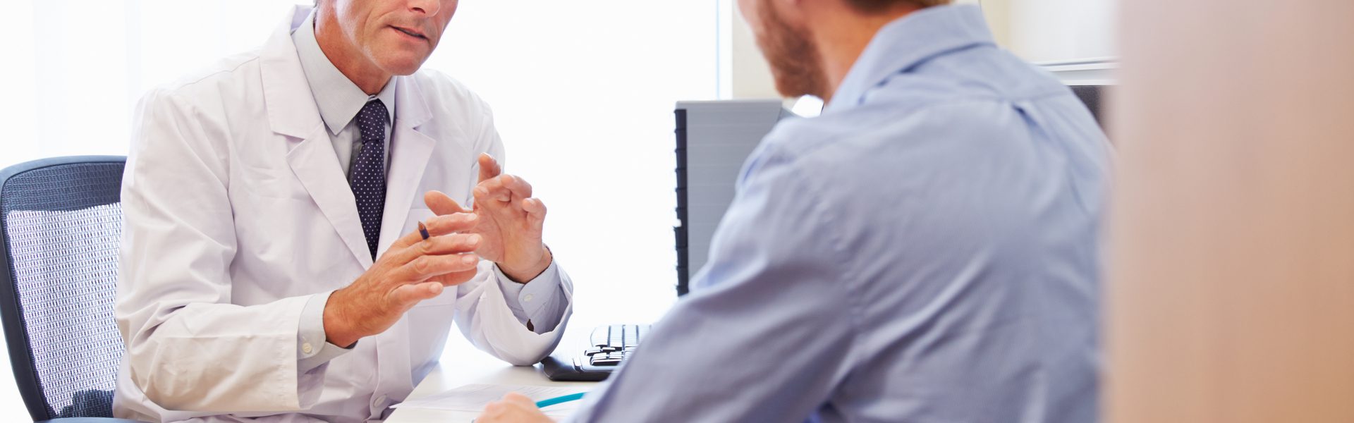 A man getting a hair restoration consultation from a hair loss doctor about an FUE hair transplant.