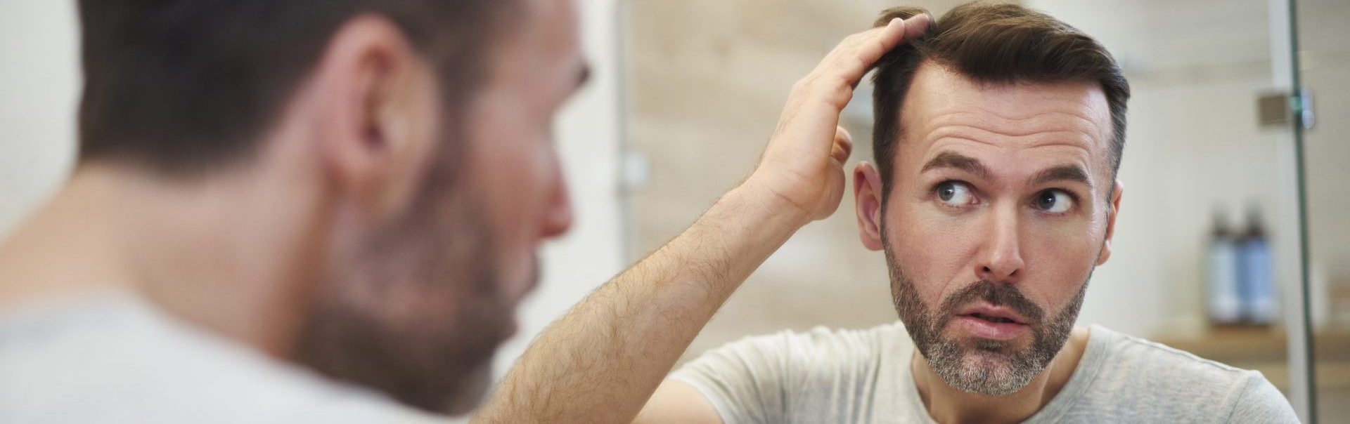 A man looking at his reasons for hair loss | Hair Implants